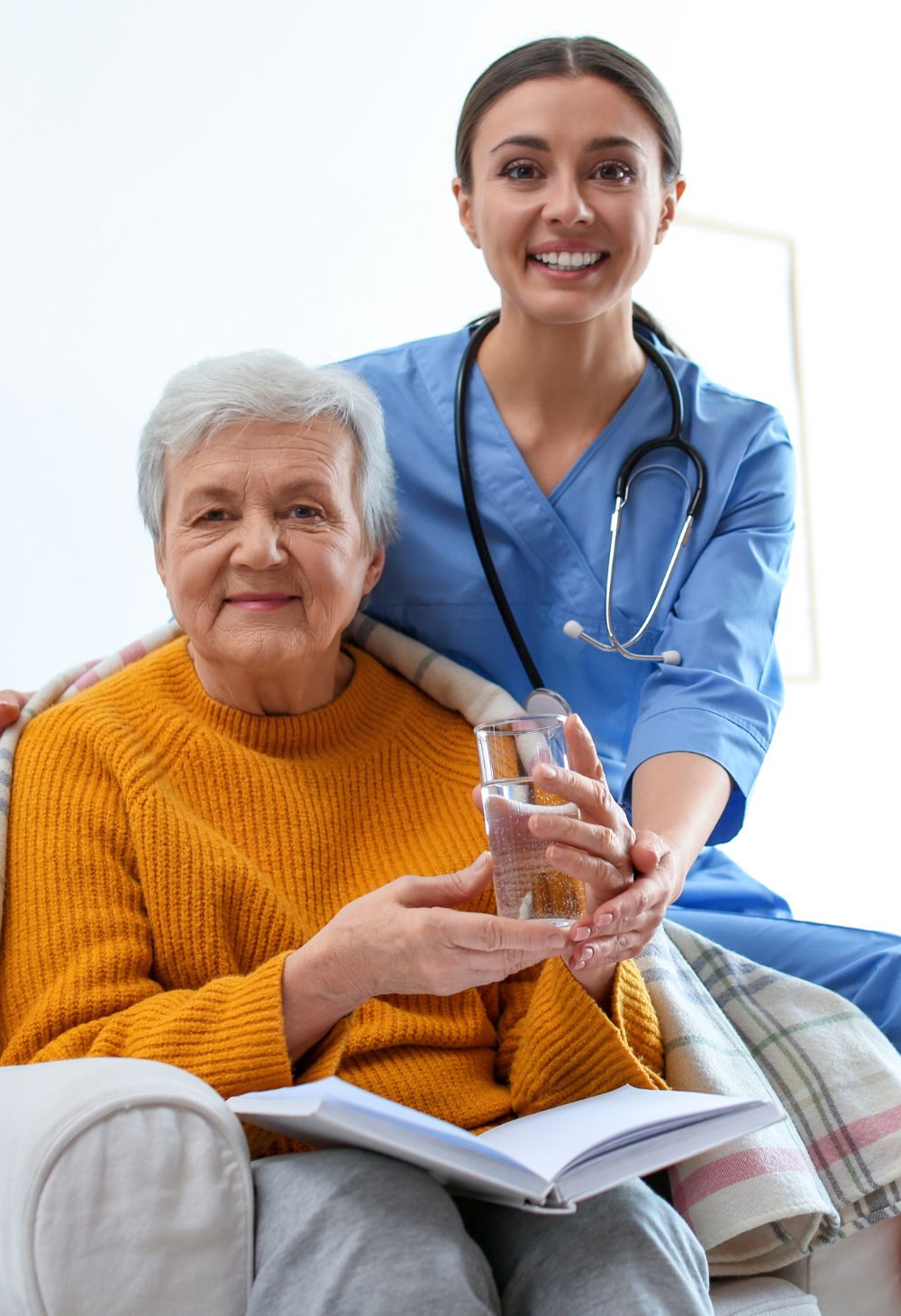 Caregiver and elderly client sharing conversation and laughter to provide companionship and emotional support.